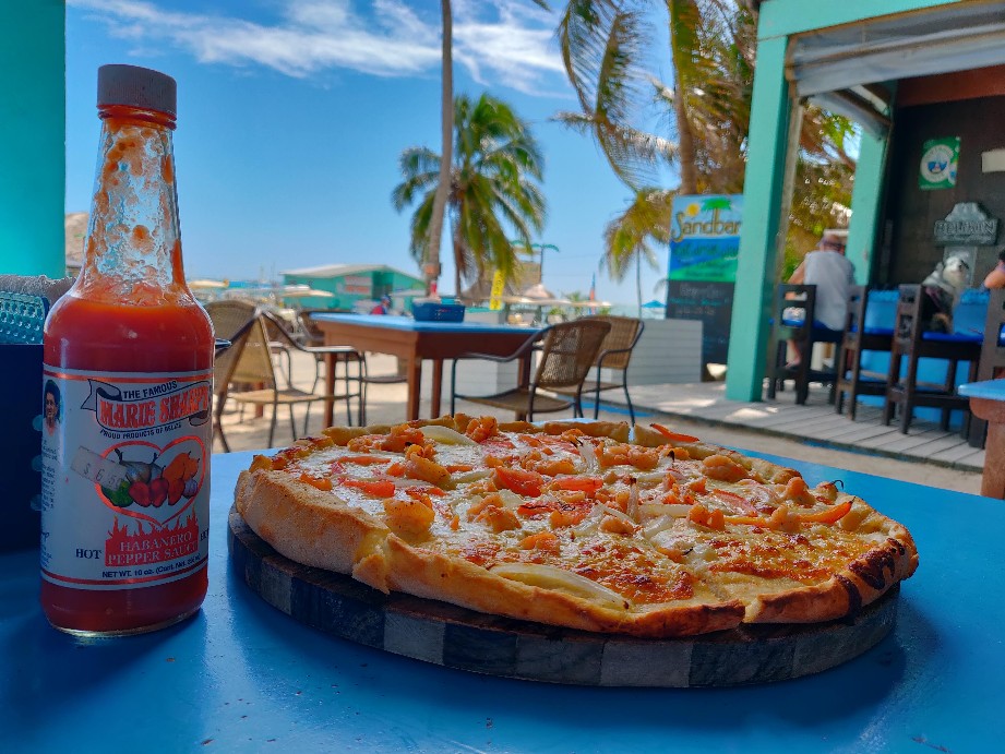 Marie Sharp's hot sauce and a shrimp pizza near the beach in San Pedro, Belize