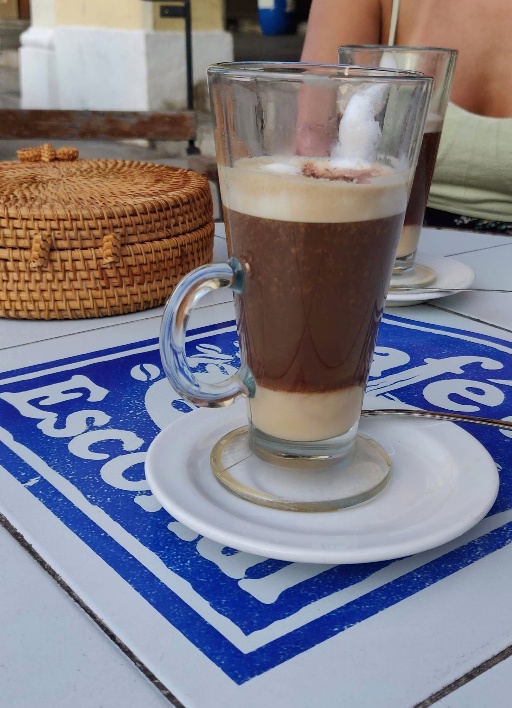 Espresso drink in glassware on a white tile patio table