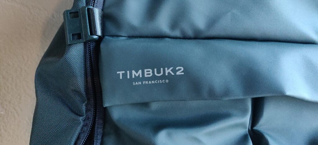 Green Timbuk2 Bruce Pack front flap logo