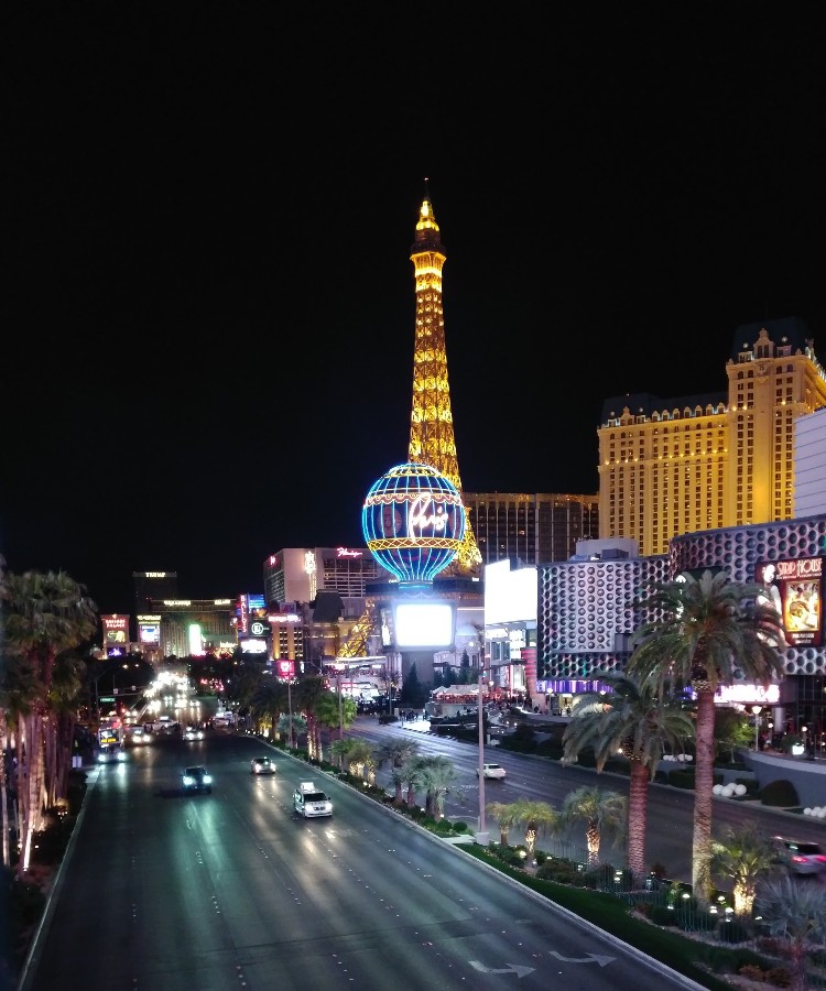 Picture of the Las Vegas strip at night with the Eiffel Tower in the background