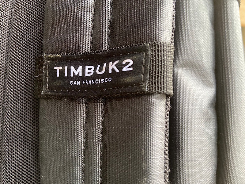 Black Timbuk2 tag on a black backpack strap
