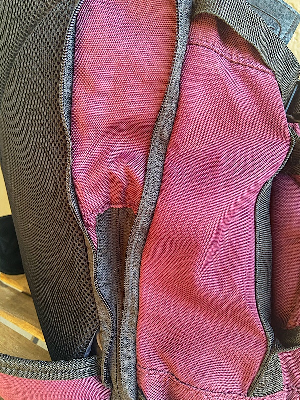 side profile of convertible carry-on with the expandable section unzipped to increase internal capacity