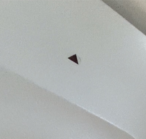 black triangle sticker on a white airplane cabin sidewall