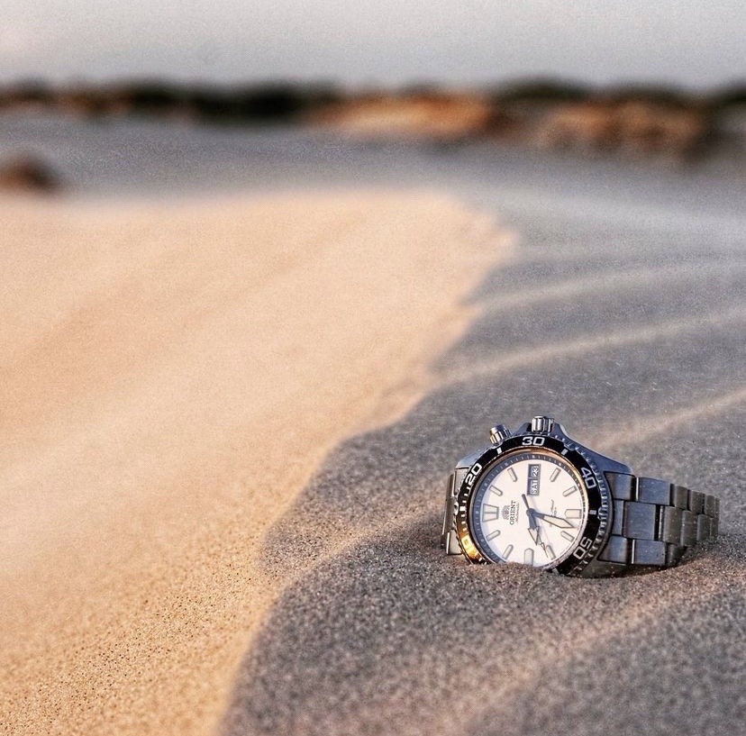 orient dive watch sitting in the sand